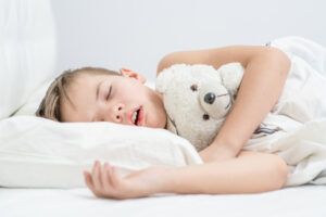 Little boy is sleeping with his mouth open, snoring